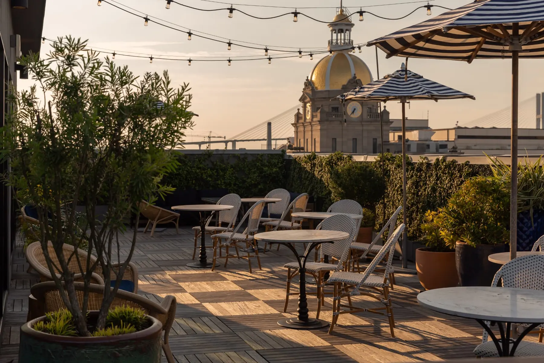Pendant rooftop terrace with striped umbrellas beside Savannah City Hall