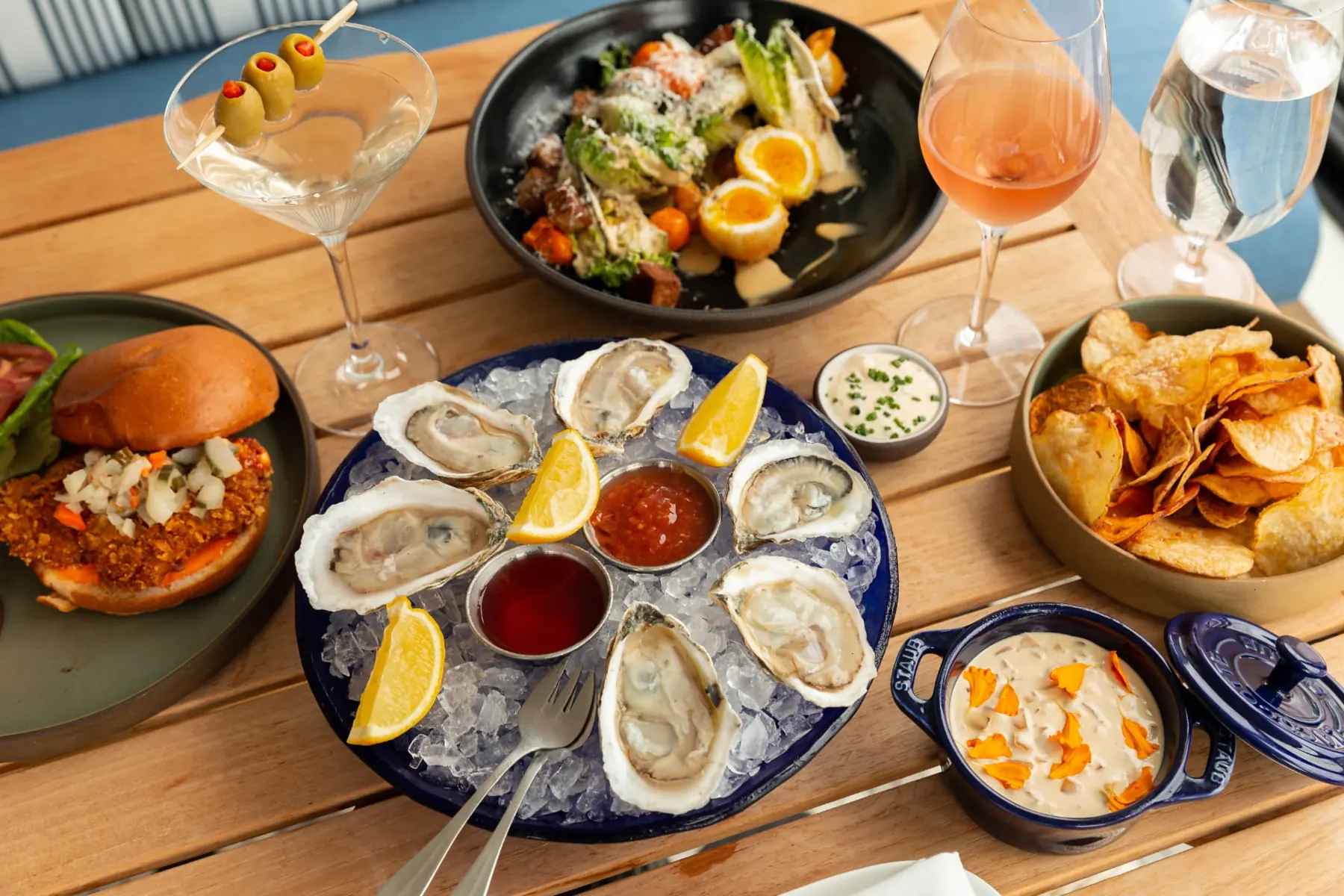 Shareable small plates and cocktails arranged on a rooftop table