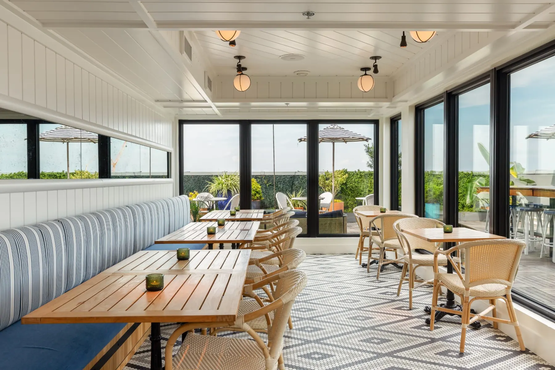 Pendant's indoor dining room with windows opening onto the rooftop terrace